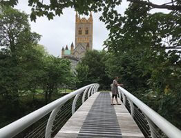 Clare Densley on river dart bridge with abbey church in background